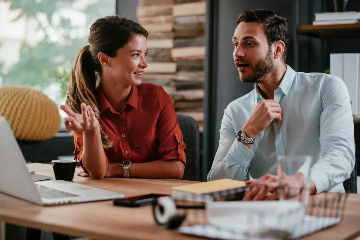 Un coach et un employé en pleine discussion constructive dans un environnement de travail collaboratif